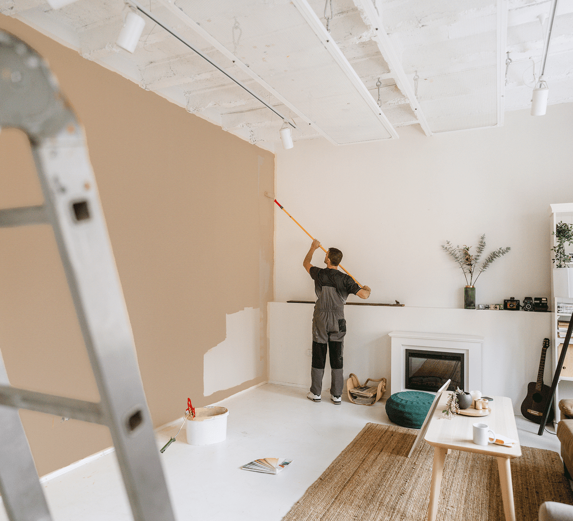 Person painting a wall in living room